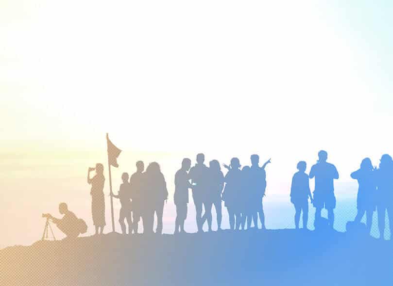 A silhouetted group of people standing together on a hill against a bright sky, suggesting unity, teamwork, and a shared purpose or journey.