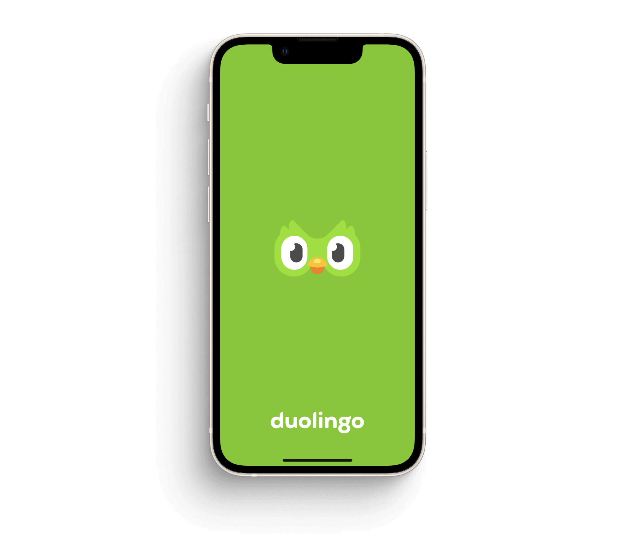 Phone displaying Duolingo owl logo on green background, viewed at an angle with shadow.