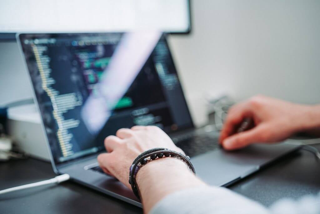 Developer writing code on a laptop, working with TypeScript in Node.js environment.