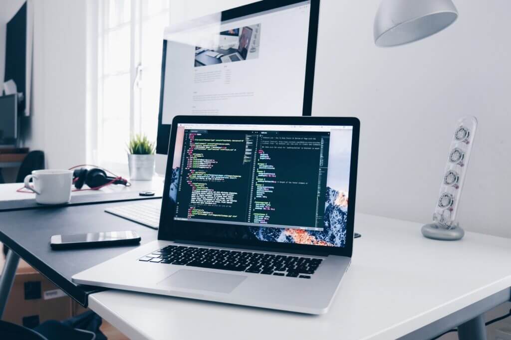 A laptop displaying code illustrates reasons to use React when building efficient and scalable web applications.