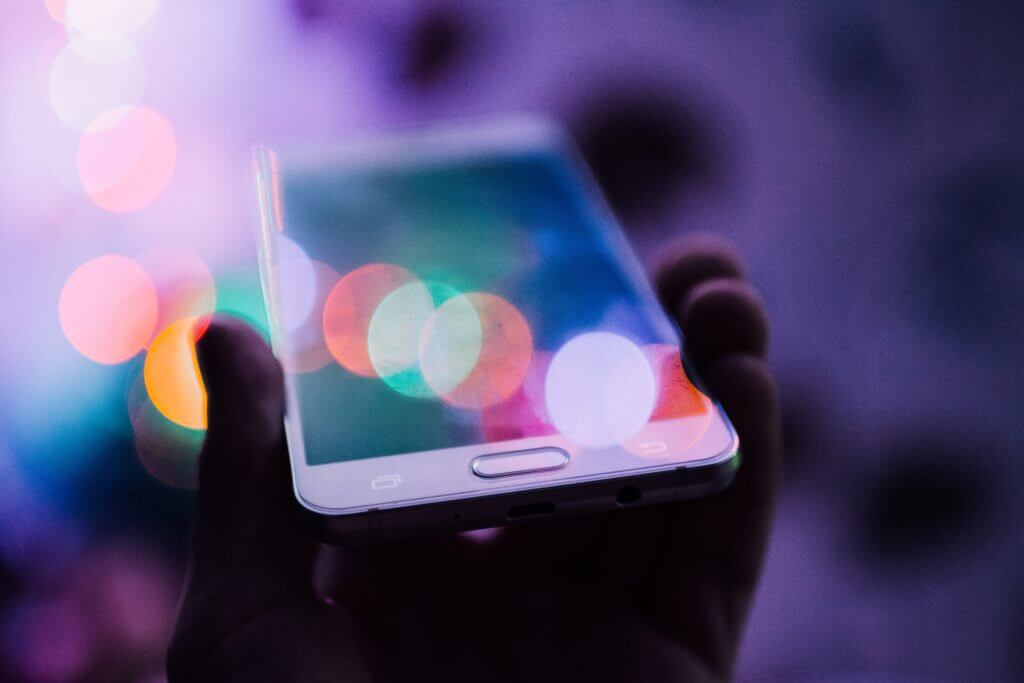 A smartphone with a vibrant screen highlights reasons to use React for creating fast and interactive mobile interfaces.